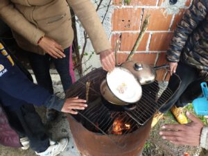 Schutzsuchende kochen Reis über einem Feuer in einem Squat in Bosnien